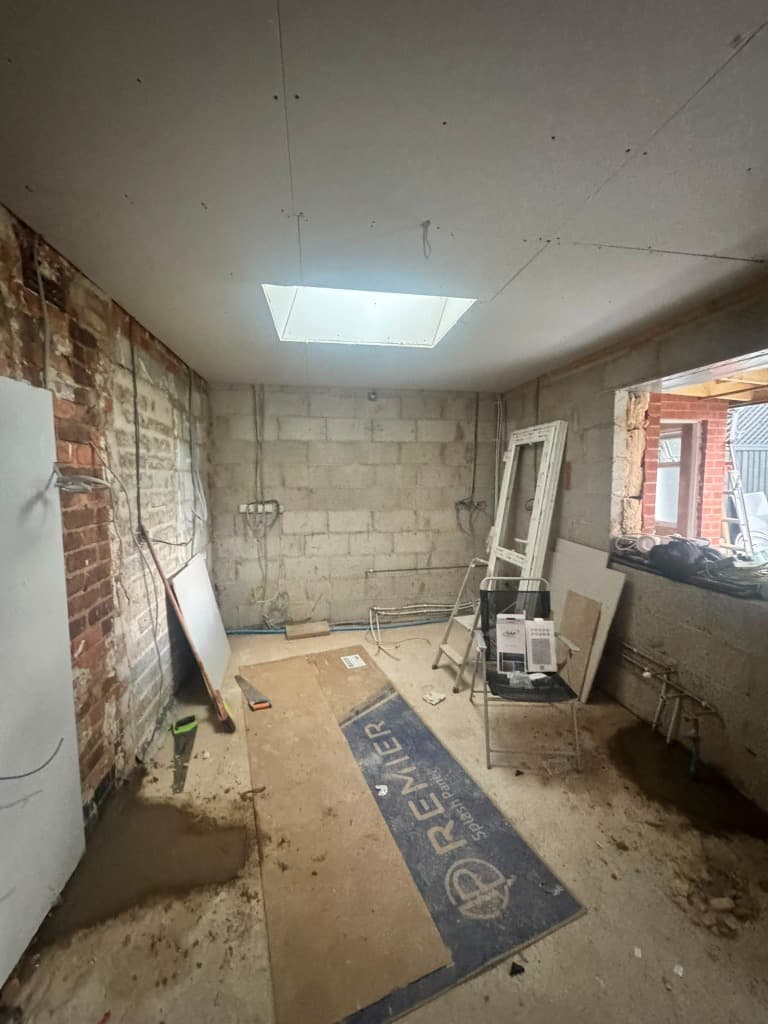 Raw kitchen space during renovation with exposed brickwork
